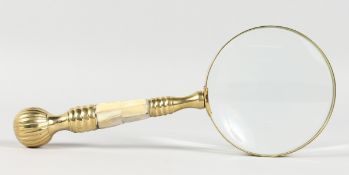A LADIES MAGNIFYING GLASS with mother-of-pearl and brass handle.