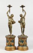 A PAIR OF 19TH CENTURY BRONZED CLASSICAL FIGURES, holding aloft candle sconces on plinths. 20ins