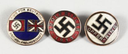 THREE CIRCULAR ENAMEL BADGES OF SWASTIKAS.
