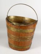 A 19TH CENTURY BRASS BOUND OVAL MAHOGANY BUCKET. 13ins high.