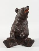 A BLACK FOREST CARVED WOOD BEAR CADDY. 8ins high.