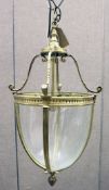 A BRASS AND GLASS HALL LANTERN, with four panels of plain curving glass. 21ins high.