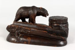 A GOOD BLACK FOREST CARVED WOOD INKSTAND AND PEN TRAY, carved with a bear. 7ins long.