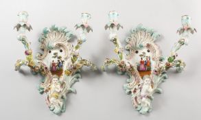 A GOOD PAIR OF MEISSEN TWO-BRANCH WALL SCONCES, encrusted with flowers and cupid, and painted with