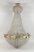 A LARGE CUT GLASS AND BRASS CHANDELIER. 36ins high.