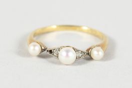A VICTORIAN GOLD AND TRIPLE PEARL RING.