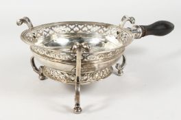 A RARE QUEEN ANNE CIRCULAR SILVER BRAZIER, pierced edge, scrolled feet and turned wood handle.