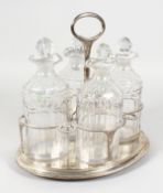 A GOOD GEORGE III OVAL FOUR BOTTLE CRUET, with four decanters and stoppers, the frame with gadrooned