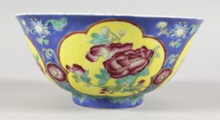 A CHINESE CIRCULAR PORCELAIN BOWL, the blue and yellow ground exterior painted with flowers. 6ins