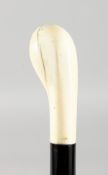 A VICTORIAN EBONY CANE with ivory handle. 34ins long.