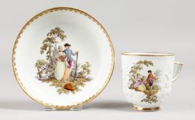 A MEISSEN COFFEE CUP AND SAUCER, prunus moulded ad painted with scenes of a courting couple.