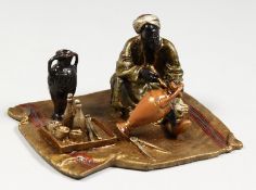 A SMALL VIENNA STYLE COLD PAINTED BRONZE GROUP OF A MAN PAINTING A VASE ON A CARPET. 4ins wide.