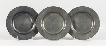 THREE EARLY PEWTER CIRCULAR PLATES, stamped LONDON. 7.75ins diameter.