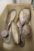 A silver backed dressing table set and two silver topped cut glass dressing table jars.