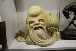 A large resin figure of a seated Buddha.