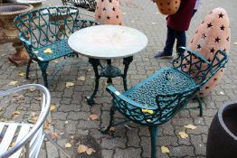 A pair of green painted cast iron modern garden benches.