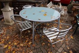 A modern circular patio table and four chairs.