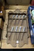 An unusual Dutch oak wall rack containing eight knives with Delft handles.