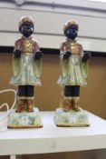 A pair of lustre glazed pottery models of blackamoors.