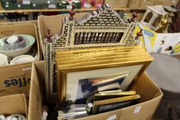 A quantity of picture frames and a decorative mirror.