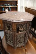 An eastern carved wood octagonal shaped table, with pierced folding stand (faults).