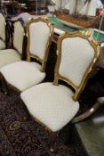 A pair of French style beech framed and parcel gilded side chairs with upholstered backs and seats