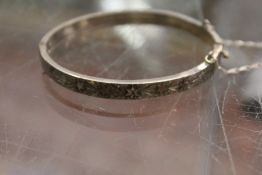 A silver bangle.