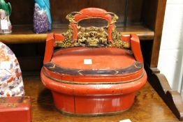 A Chinese red lacquer box with carved wood handle.