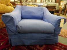 A modern armchair with blue loose covers.