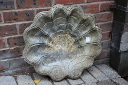 A shell shaped birdbath top.