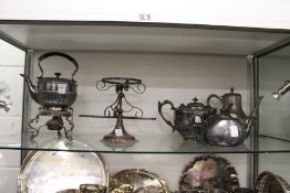 A plated kettle on stand and other items.