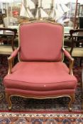 A French style open armchair with crimson upholstery.