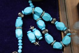 A turquoise necklace and matching earrings.