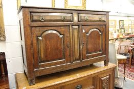 A 18th century oak small dresser base, with two drawers above two fielded panelled cupboard doors.