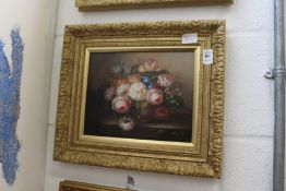 A still life of flowers in a vase on a ledge, oil on board in a decorative gilt frame.
