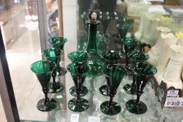 A green glass decanter and ten matching wine glasses.