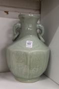 A Chinese celadon glazed moulded porcelain twin handled vase.