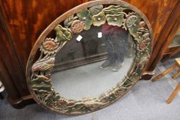 A large decoratively carved circular wall mirror.
