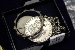 A silver St Christopher and chain together with an 1883 one dollar piece mounted as a brooch.
