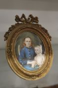 A good 19th century French oval portrait miniature of a mother and child in an ormolu easel frame.