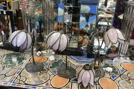 Three Art Nouveau style bronze table lamps with opaque glass shades.