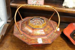A Chinese lacquer basket with wicker handle.