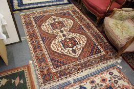 A Persian rug, the central cream ground panel with stylized decoration.