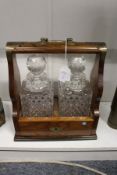 An oak tantalus with a pair of cut glass decanters.