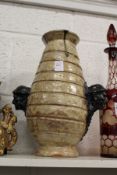 An unusual continental vase, the handles modelled as human heads.
