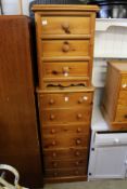 A tall pine modern chest of drawers and a similar smaller chest.