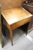 A 19th century elm desk with rising lid, on tapering square legs.