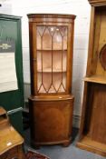 A mahogany standing corner cabinet.