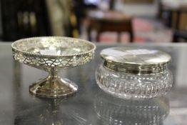 A small silver pedestal dish with pierced sides, together with a silver lidded cut glass dressing