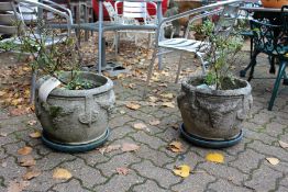 A pair of reconstituted stone garden pots.